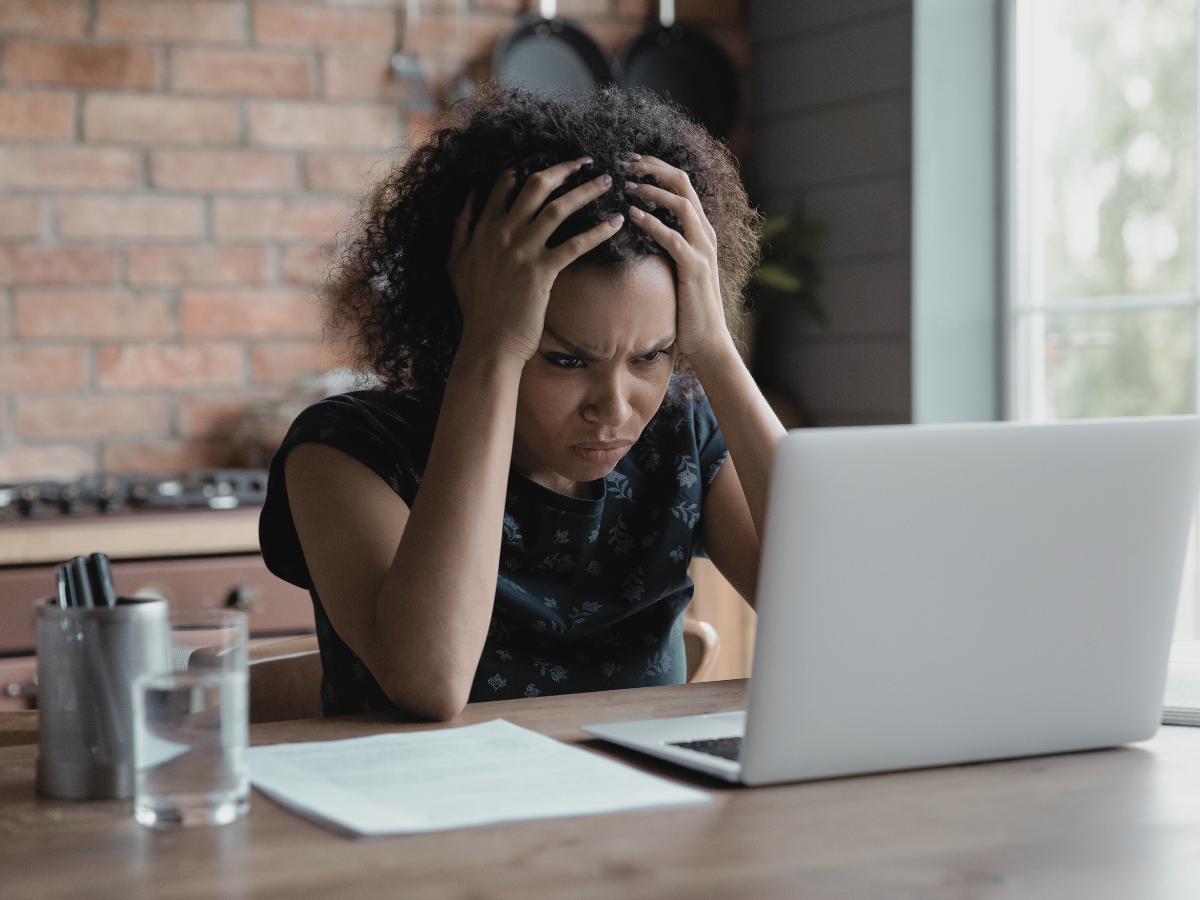 woman hands on head staring at computer